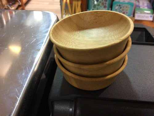 Stacked Bambu small condiment cups made from organic bamboo, showcasing natural grains.