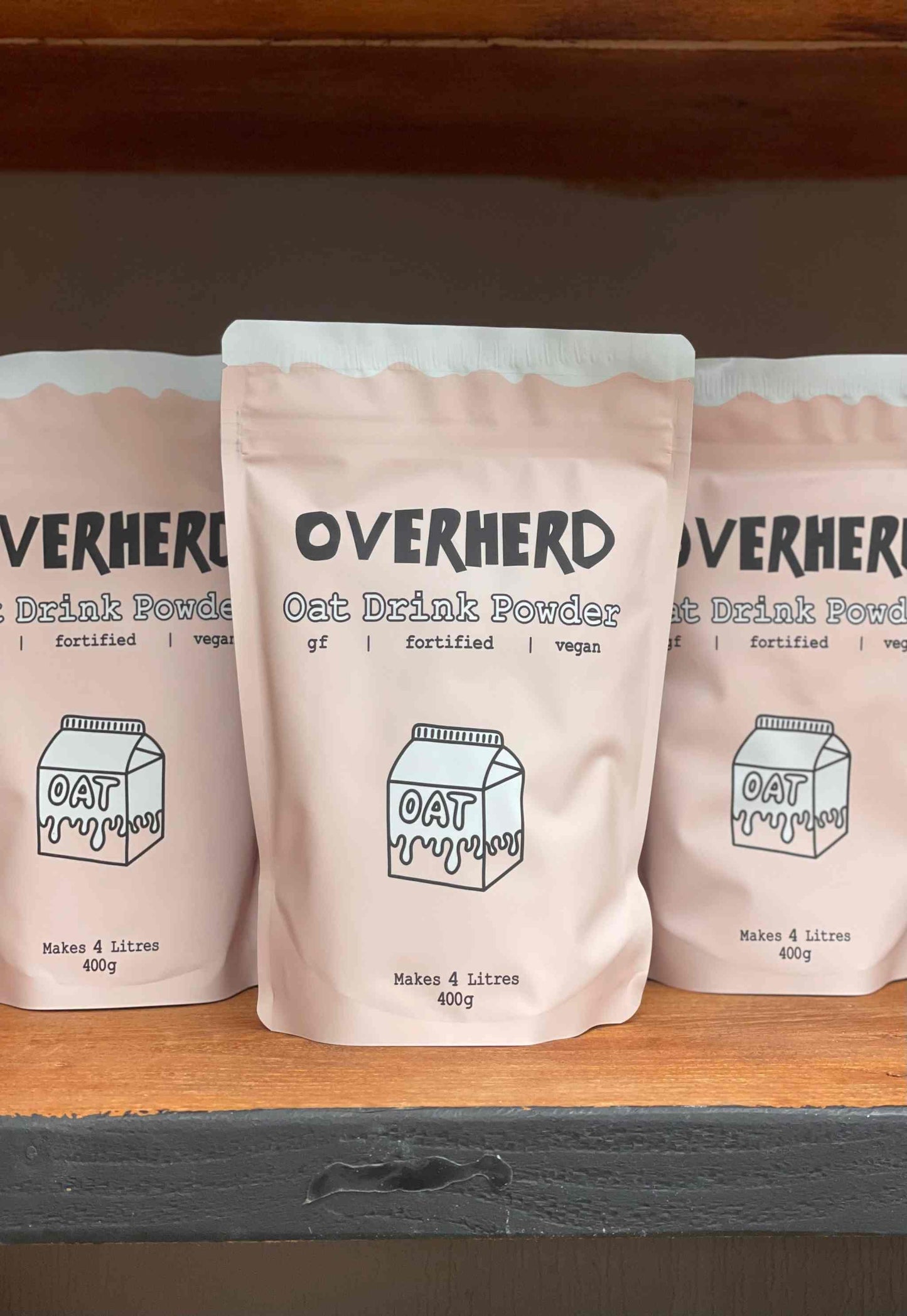 Overherd Powdered Oat Milk packaging on a shelf displaying multiple bags.