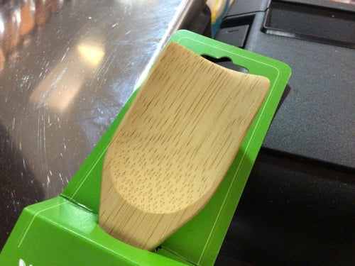 Eco-friendly bamboo coffee scoop on packaging.