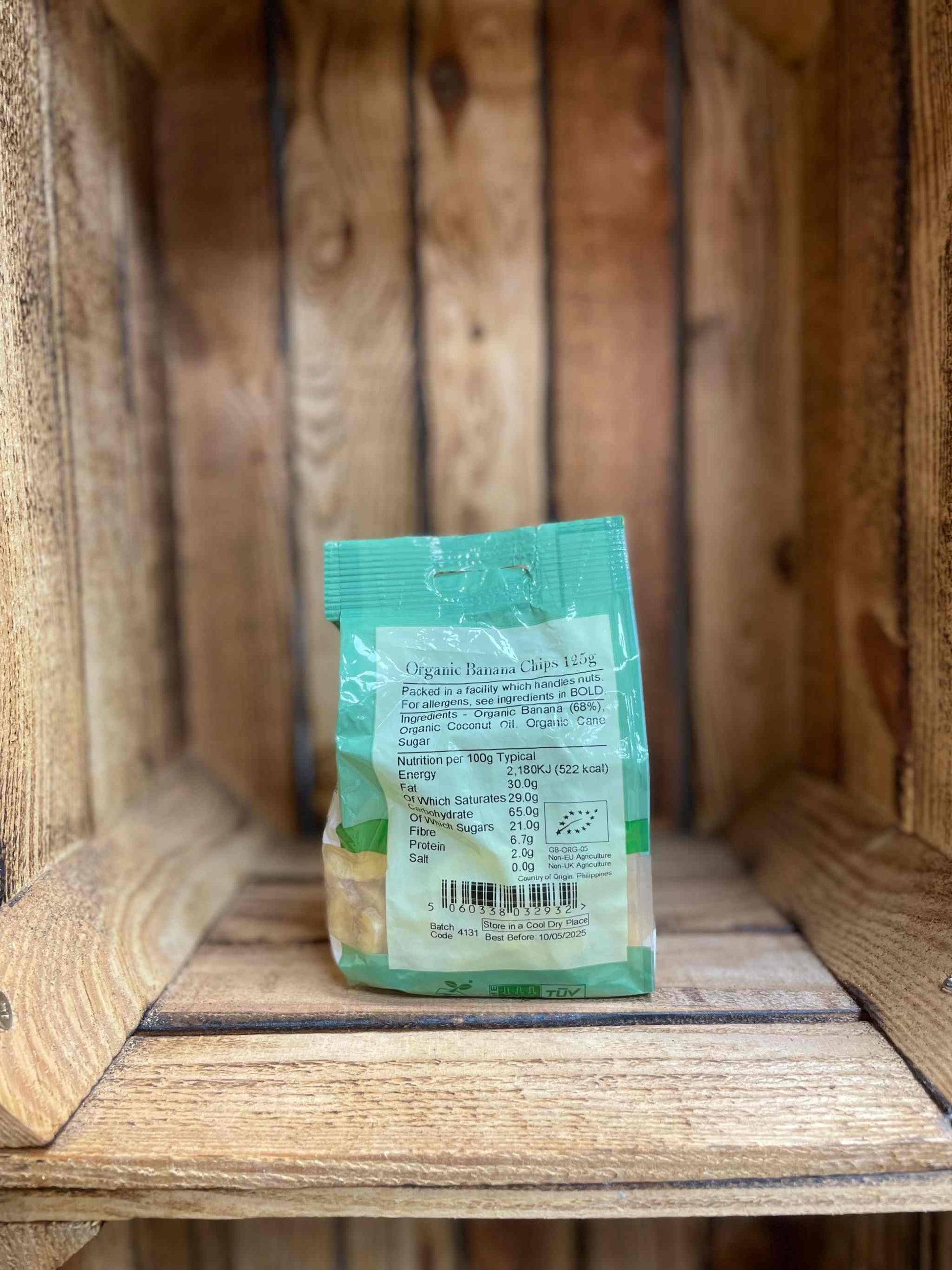 Organic banana chips in eco-friendly packaging on a wooden shelf.