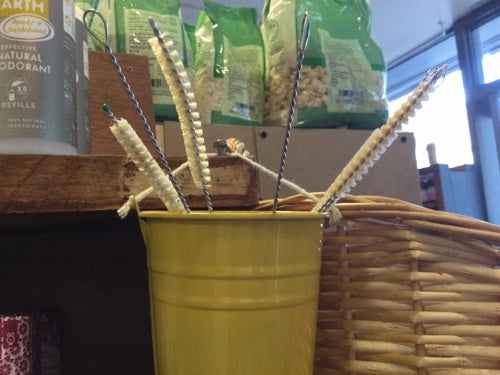 Single straw cleaner in a yellow container with cleaning bristles.