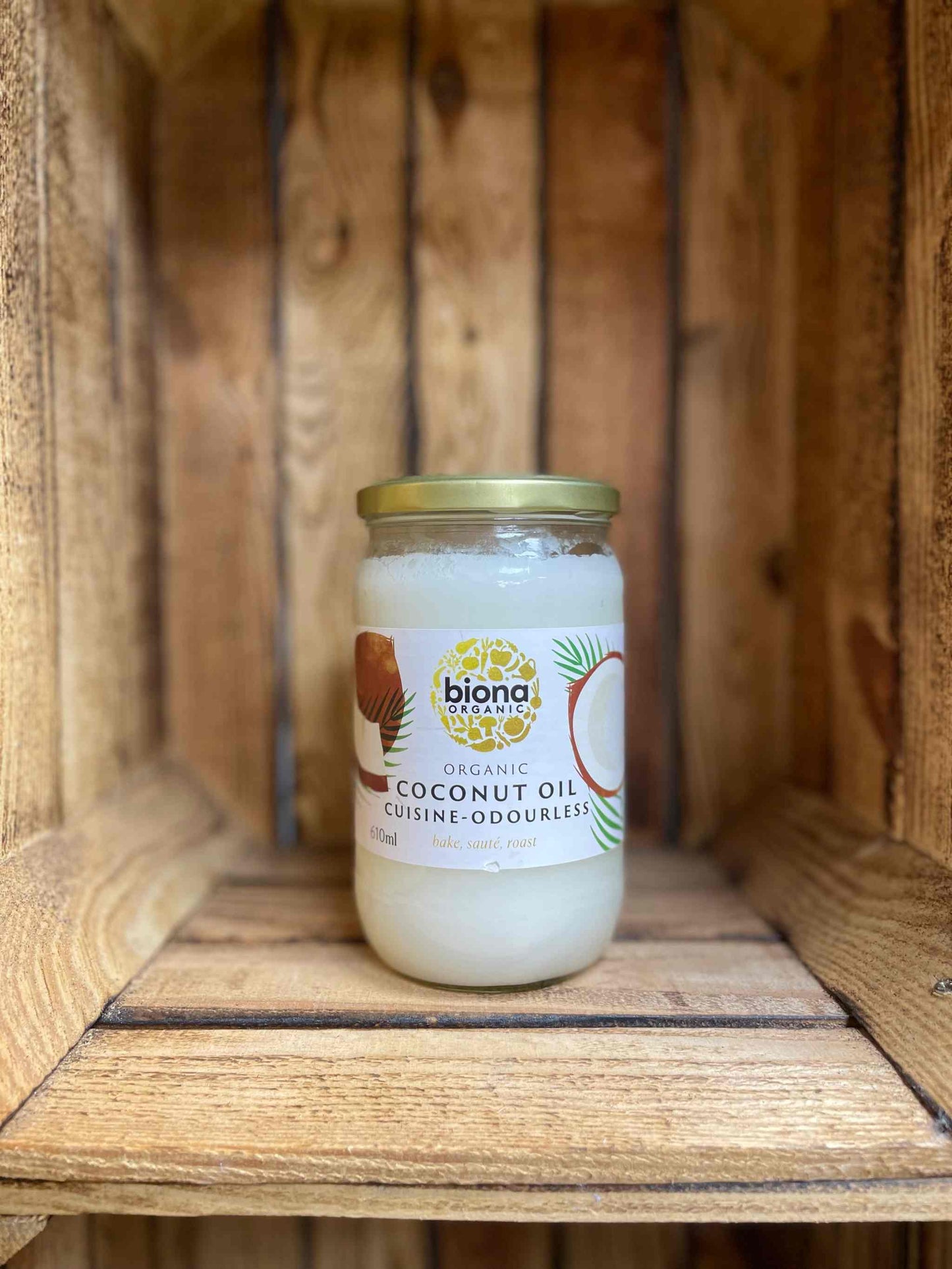 Coconut Oil Odourless Biona jar placed in a wooden crate, showcasing premium cooking and beauty oil.