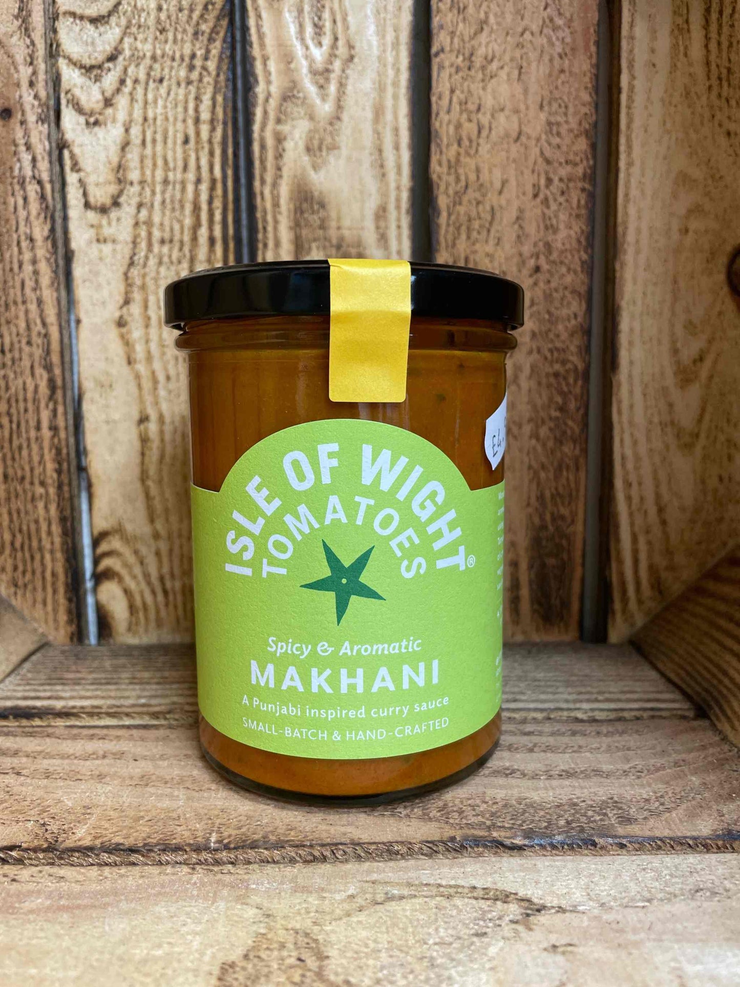 Makhani IOW Punjabi curry sauce jar with Isle of Wight label on a wooden background.