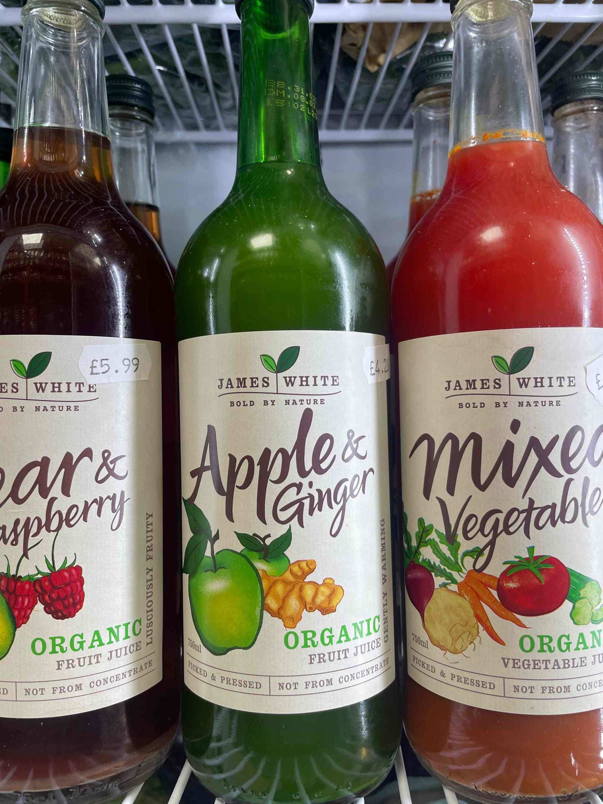 James White Juice - apple and ginger bottle on a shelf with other organic juices.