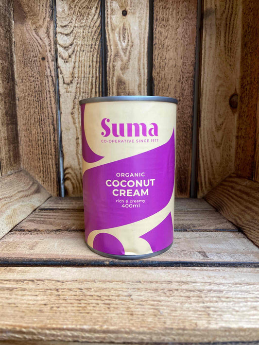 Organic coconut cream in a 400ml can with a purple label displayed on a wooden background.