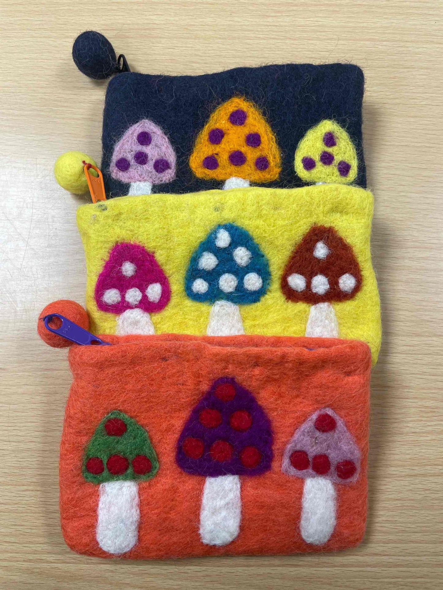 Handmade mushroom purse from recycled felt with colorful mushroom designs.