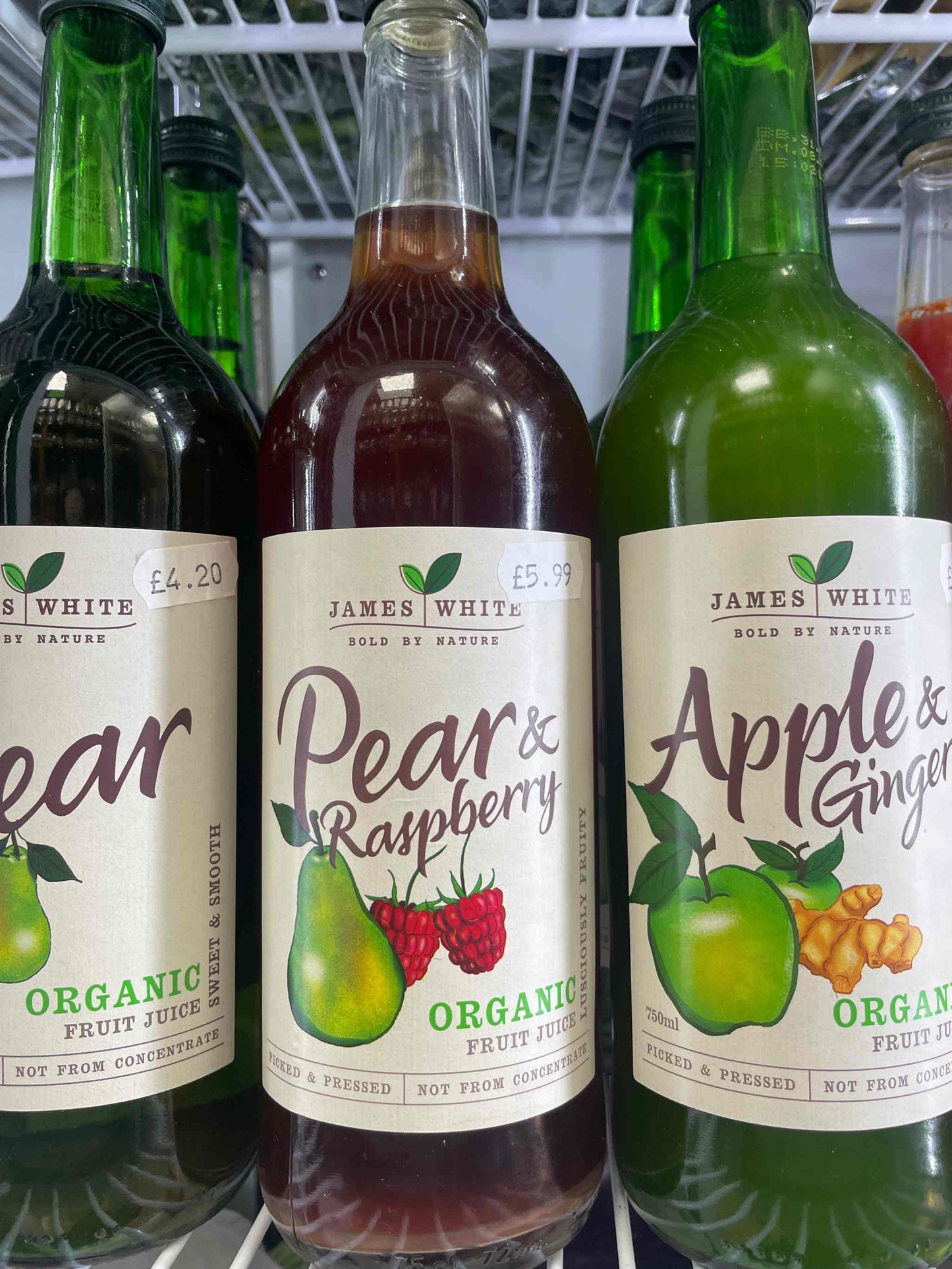 James White Juice pear and raspberry bottles displayed in a fridge.