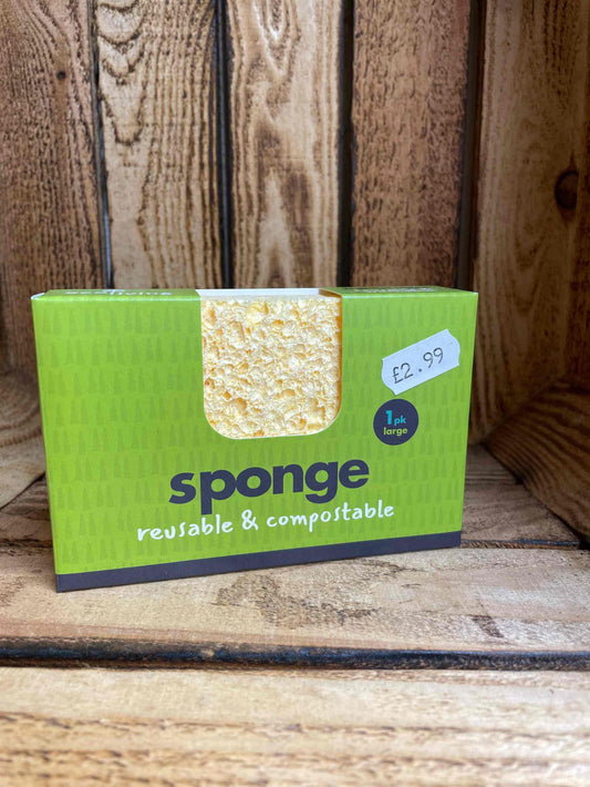 Compostable sponge single large in eco-friendly packaging on wooden background.