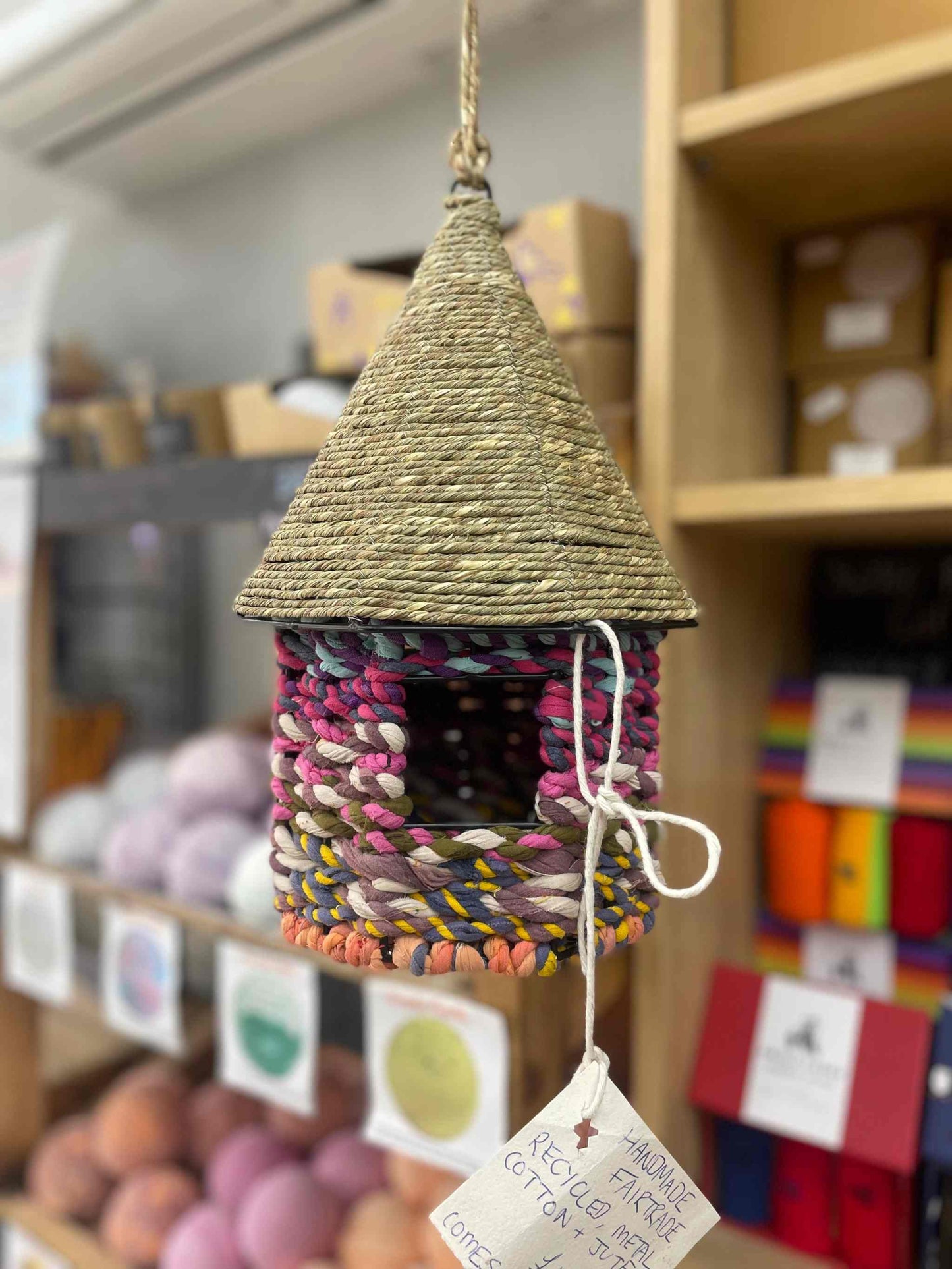 Eco-friendly birdhouse made from upcycled cotton with rustic charm, ideal for garden decor.