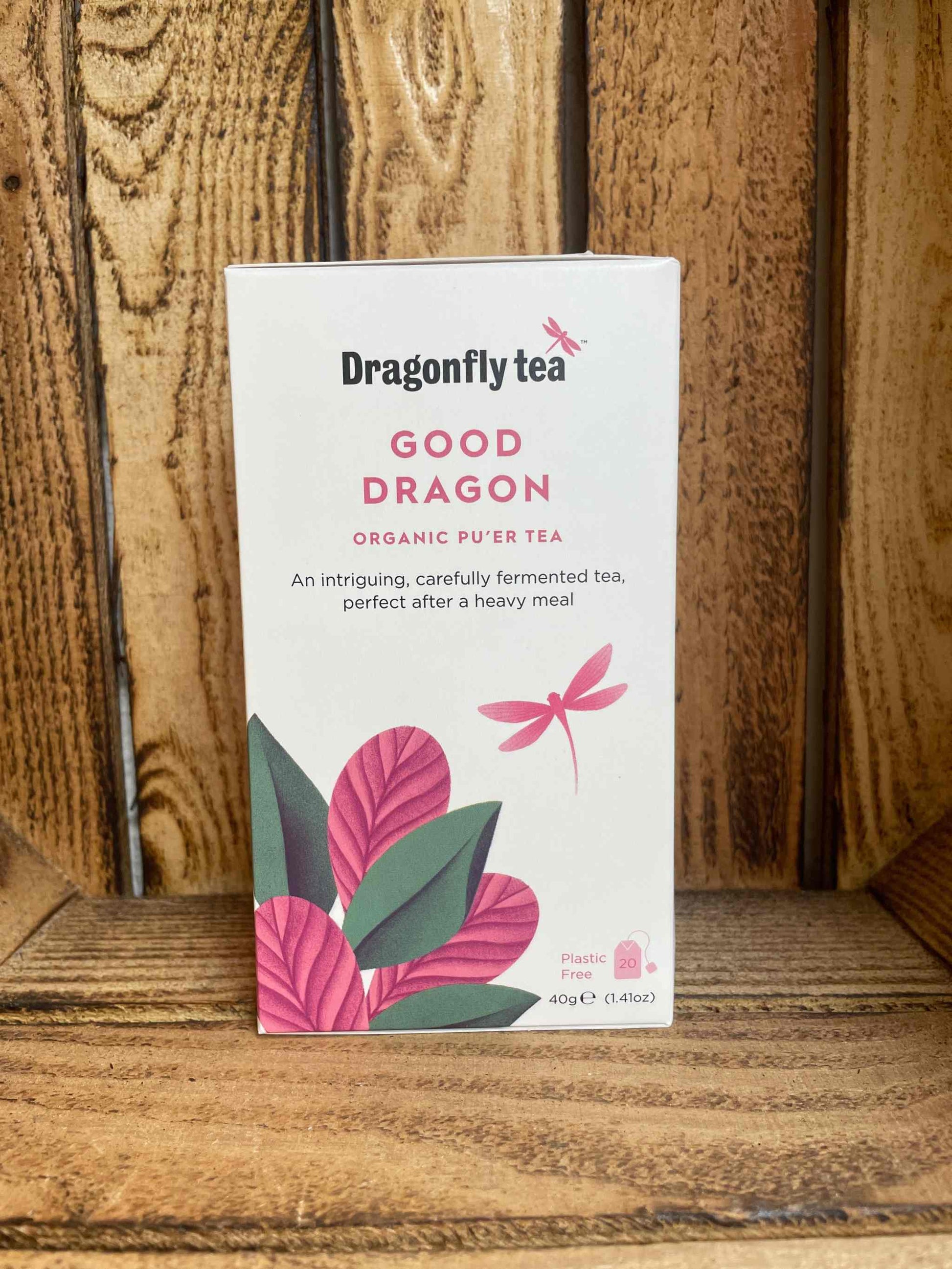 Good Dragon Tea organic puer tea box with dragonfly logo on wooden background.