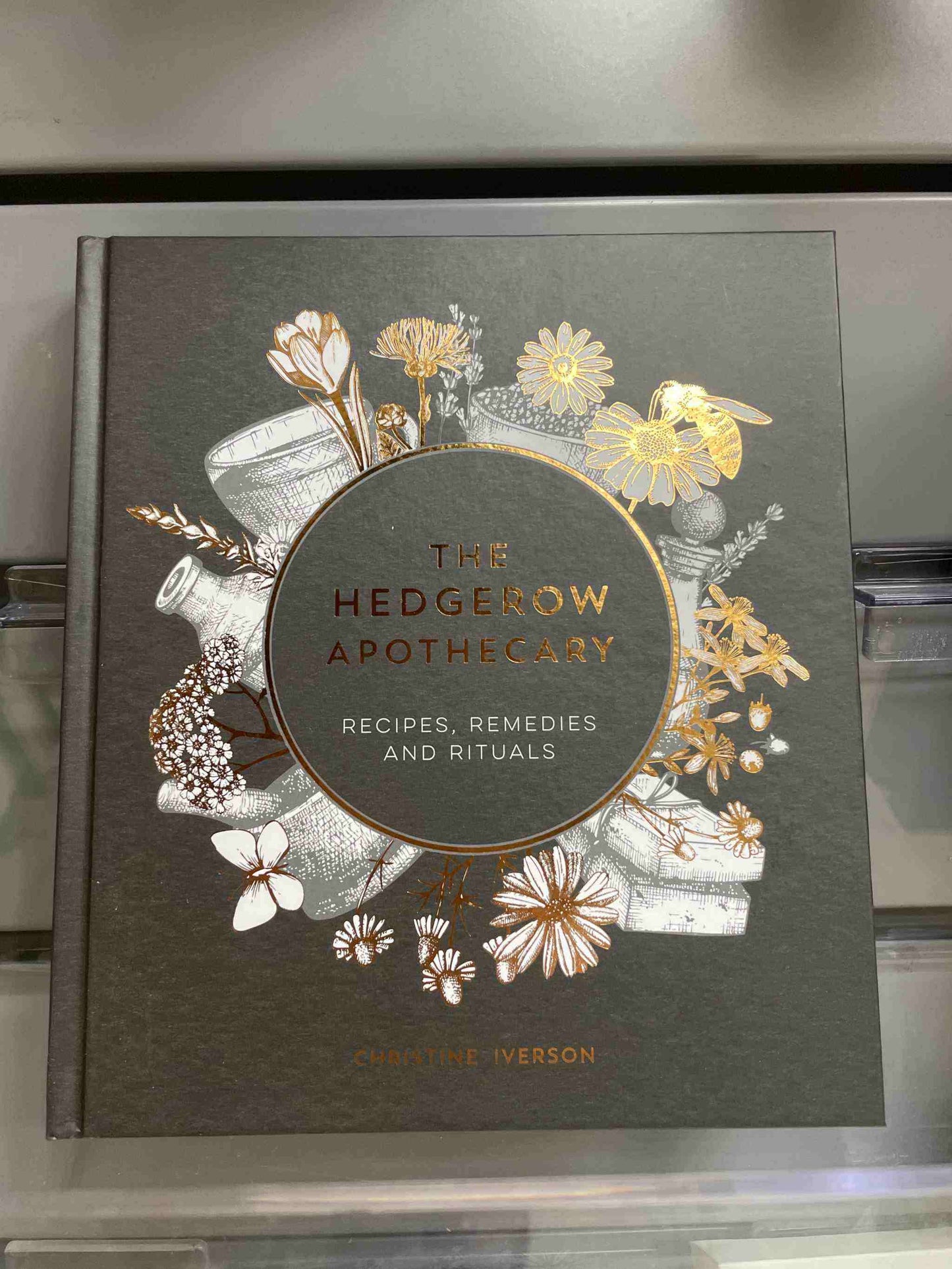 The Hedgerow Apothecary book cover with floral illustrations.