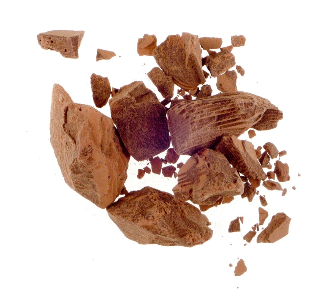 Chunks of organic ceremonial cacao on a white background.