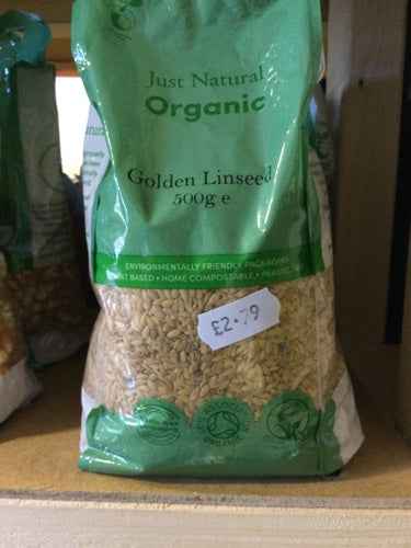 Organic golden linseed 500g package on shelf with price tag.